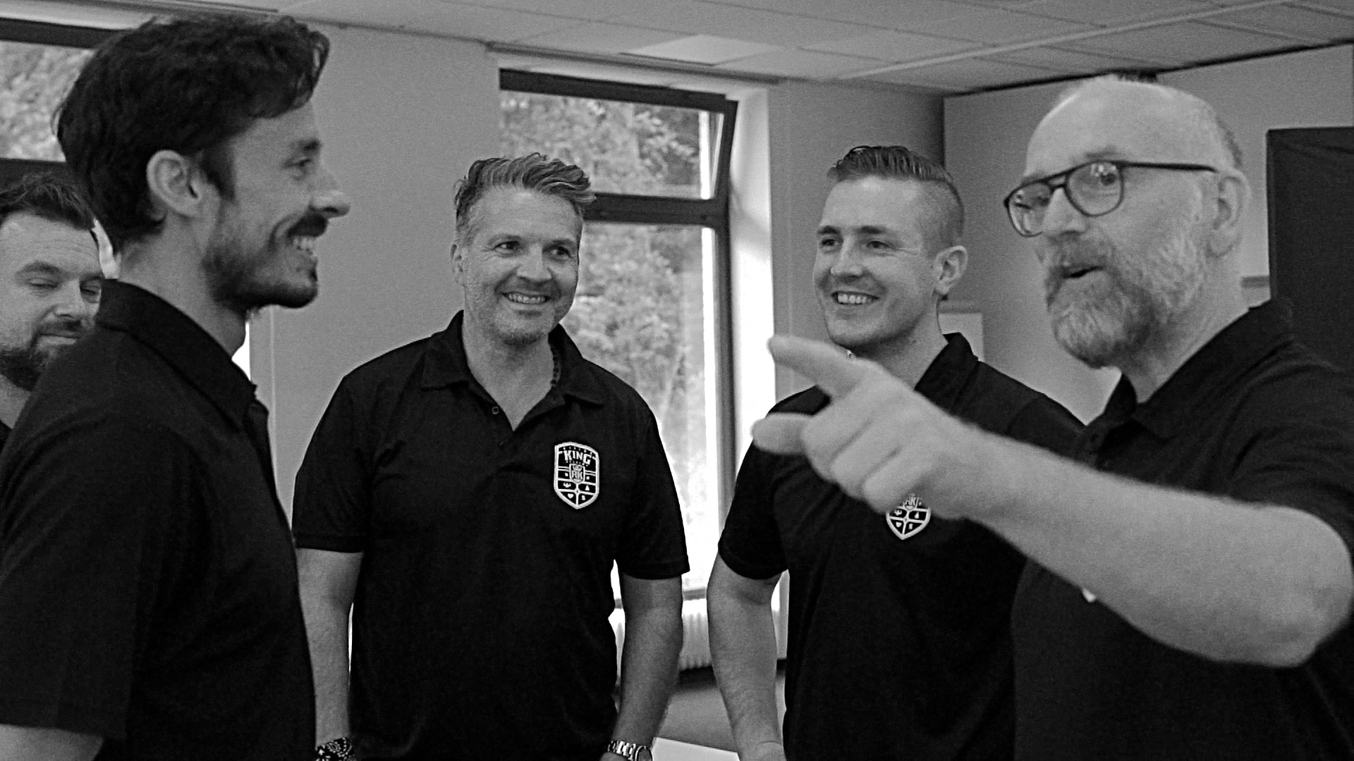 Schwarz-weiß Foto mit vier lächelnden Männern beim Unternehmer-Workshop